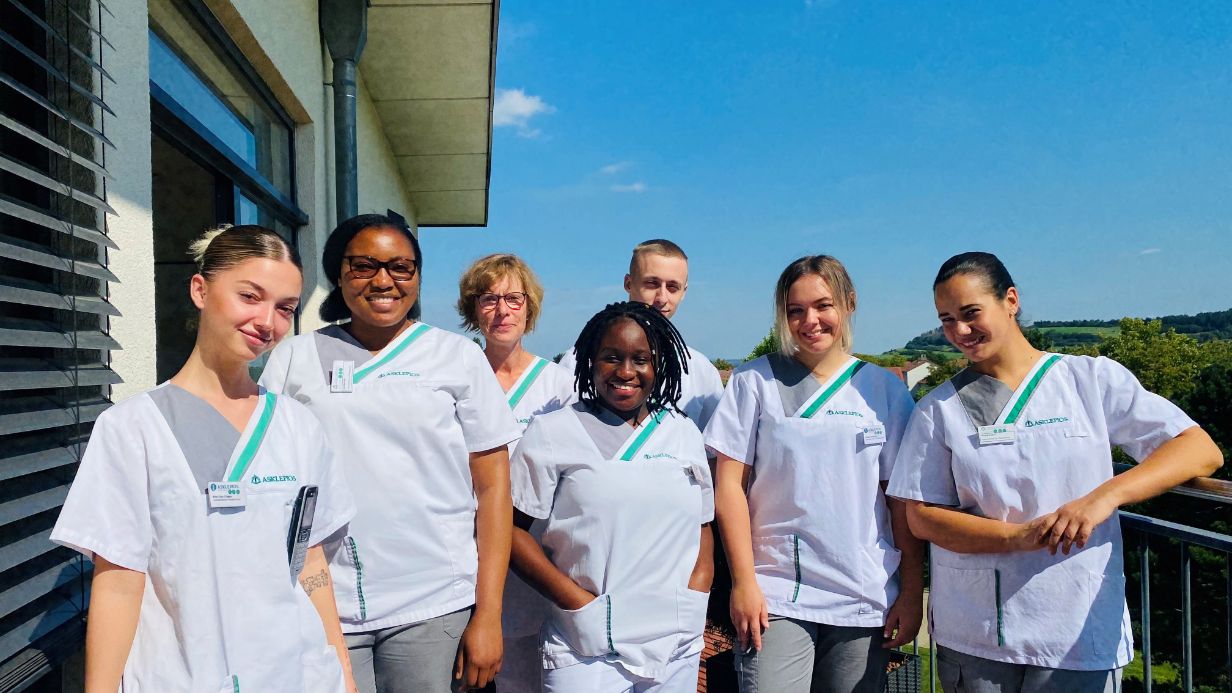 Pflegeteam auf einer sonnigen Klinikterrasse